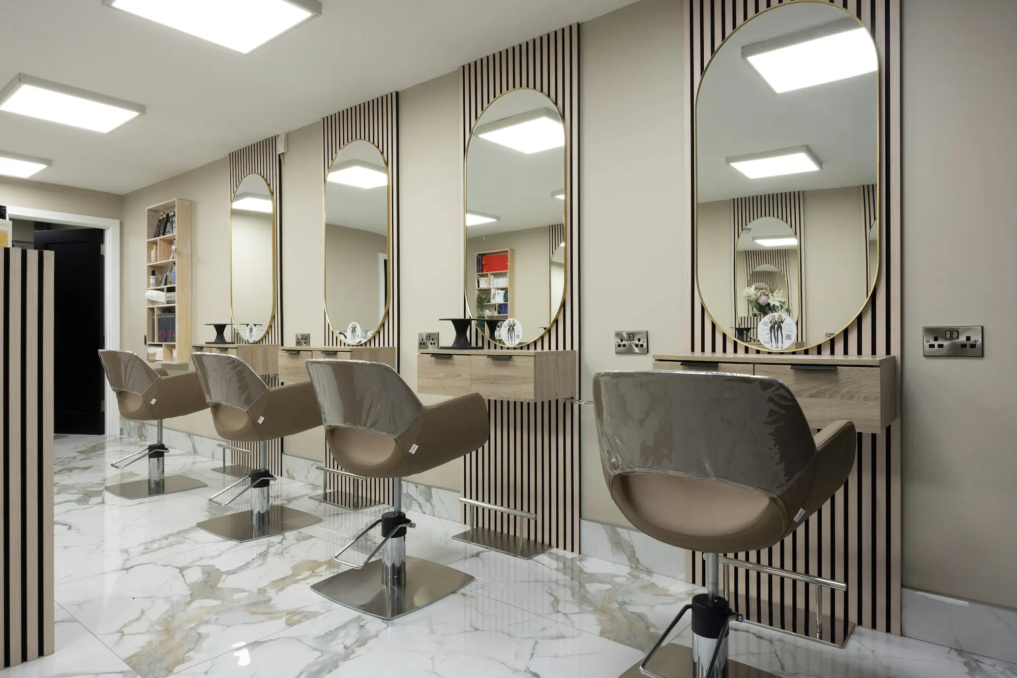 Interior luminoso de una peluquería con sillones, espejos y buena iluminación: peluquería y estética en Santa Isabel (Zaragoza)