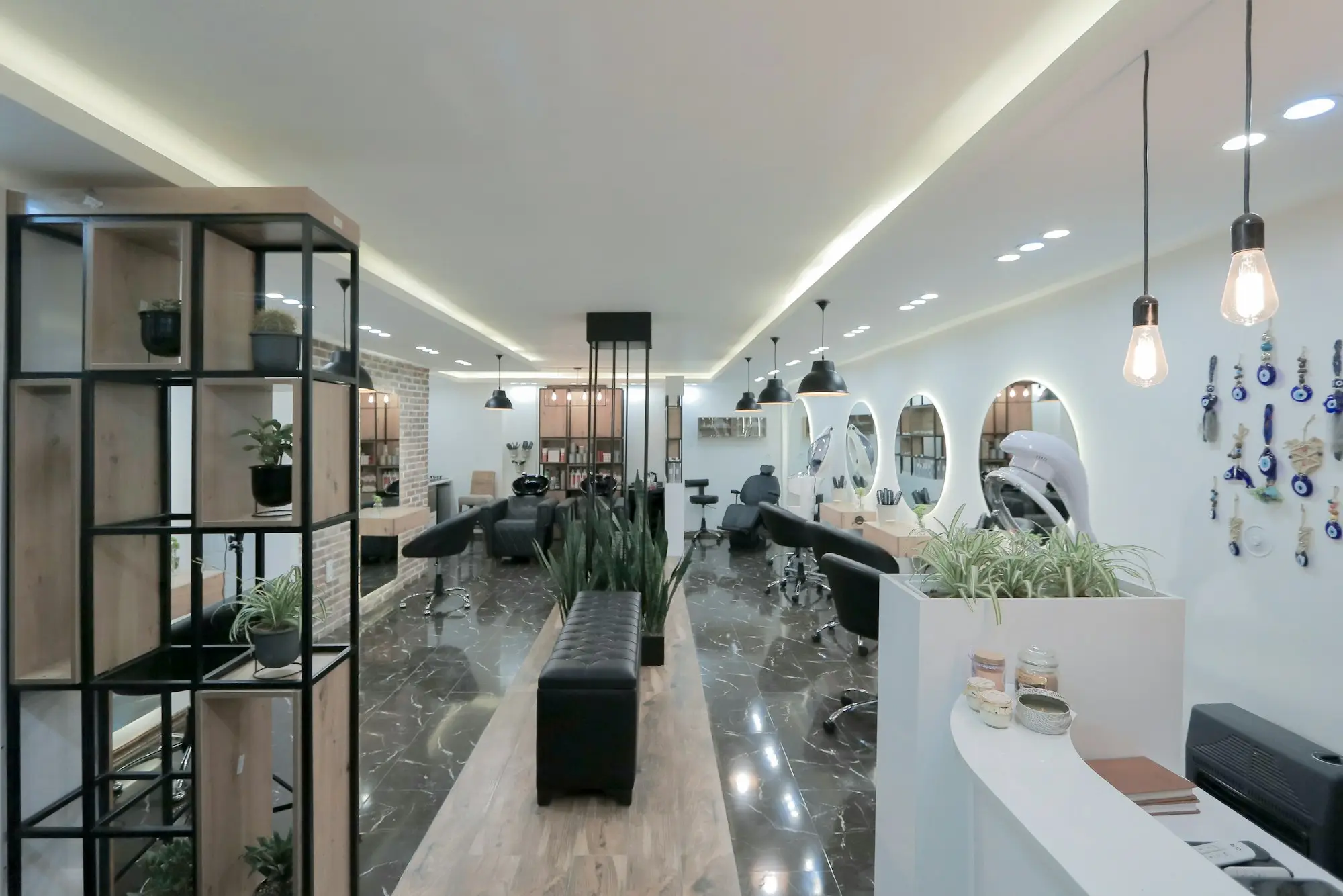 Interior luminoso de una peluquería con sillones, espejos y buena iluminación: peluquería y estética en Santa Isabel, Zaragoza